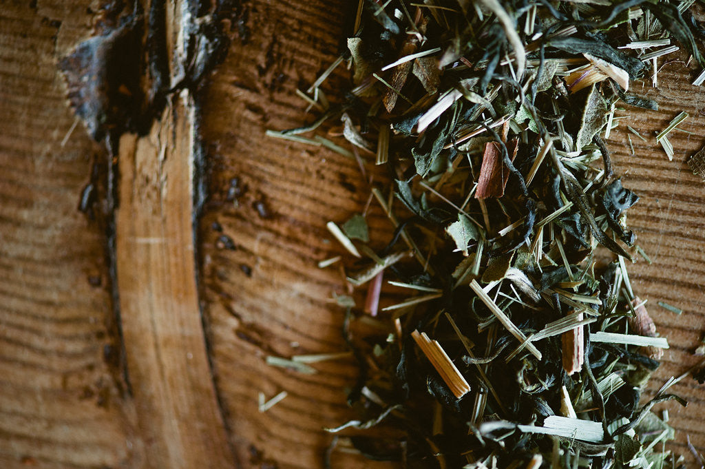 Delicious looking loose leaf tea spread over Fir tree slice.