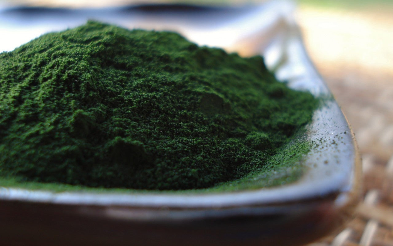 Shadowed small pile a vibrant looking green atcha blend powder.