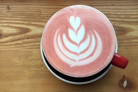 Cup of Organic Beet Pow Latte Mix with a perfect flower art made by a barista.
